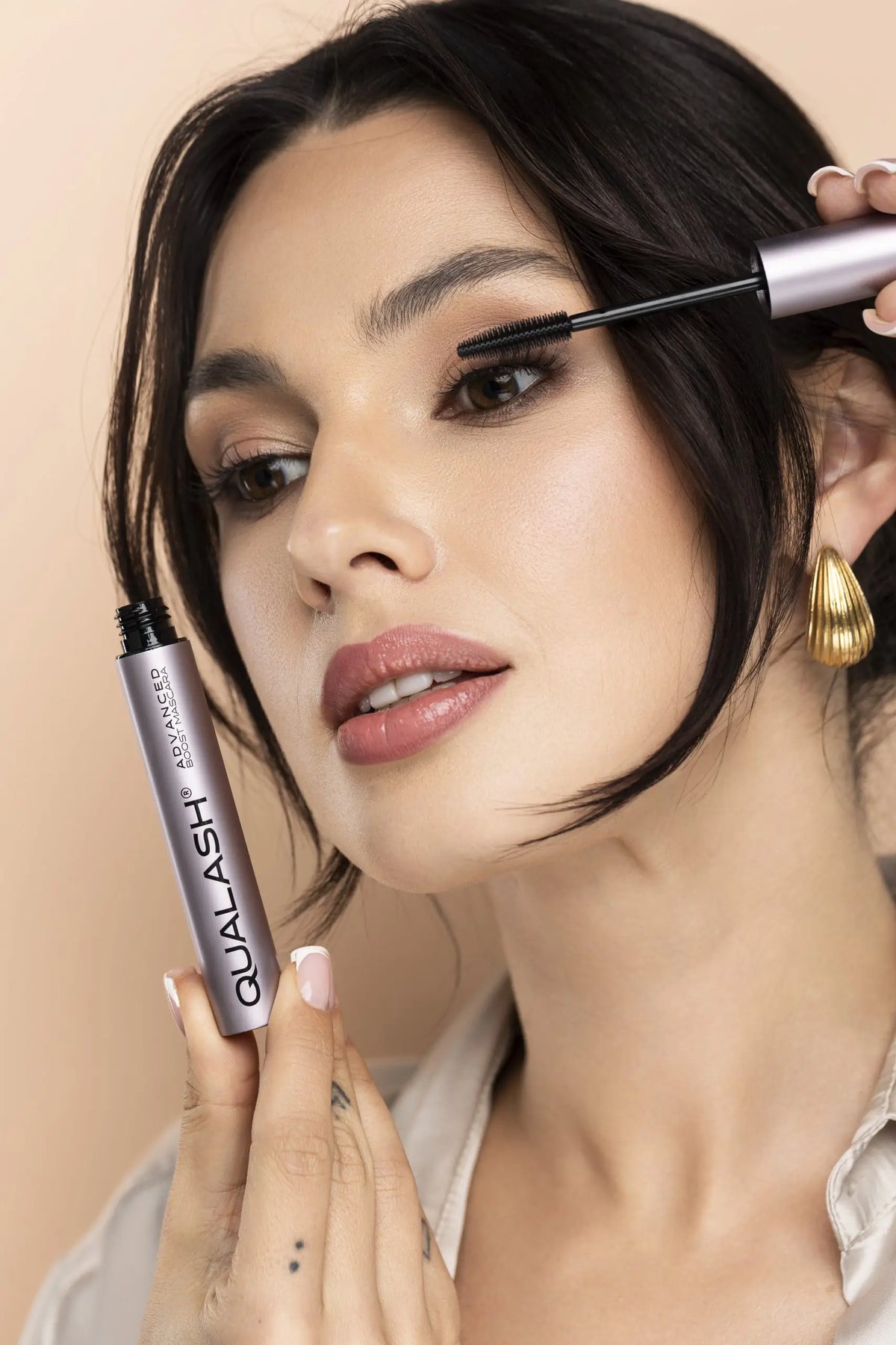 alt
Glimlachende vrouw die QUALASH Advanced Mascara Volume Max vasthoudt na het aanbrengen – Stap 2