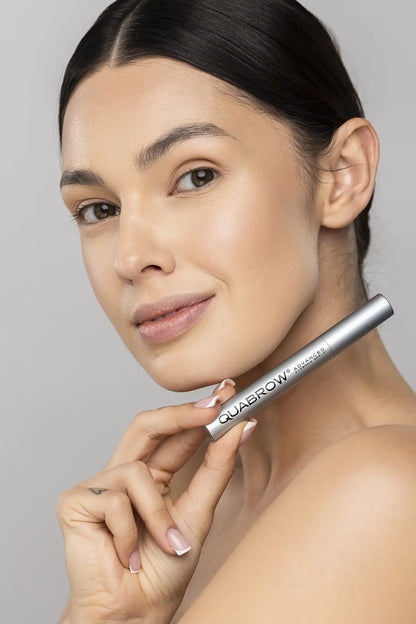 Woman applying QUABROW Advanced Eyebrow Serum directly to the brow line using the applicator – Step 1