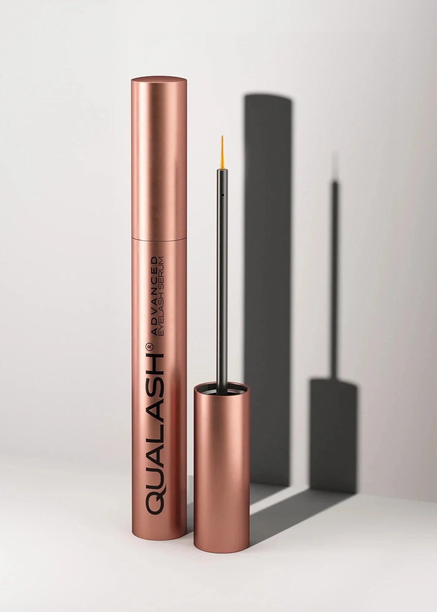 QUALASH DUO Eyelash Serum photographed with soft shadow on white background